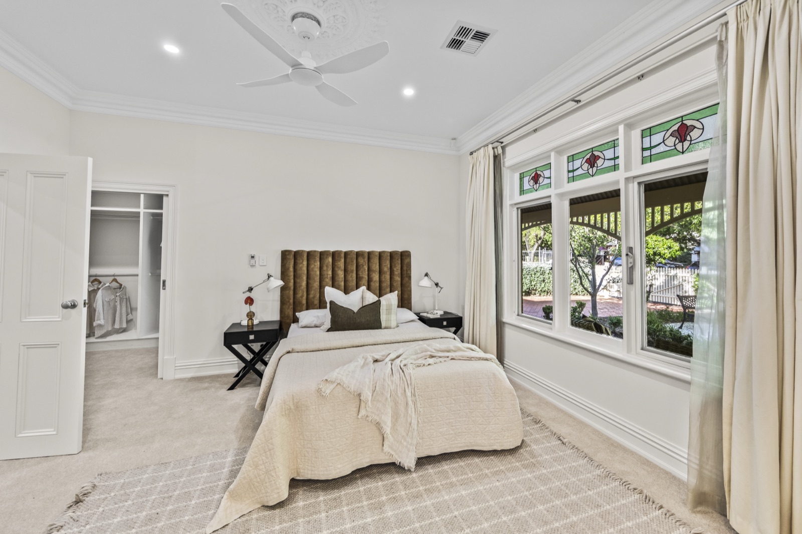 Renovated bedroom staged for sale with fresh neutral paint and new carpet