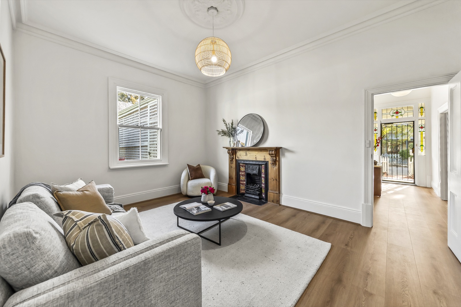 Renovated front living room styled for sale, opening to the entrance hall