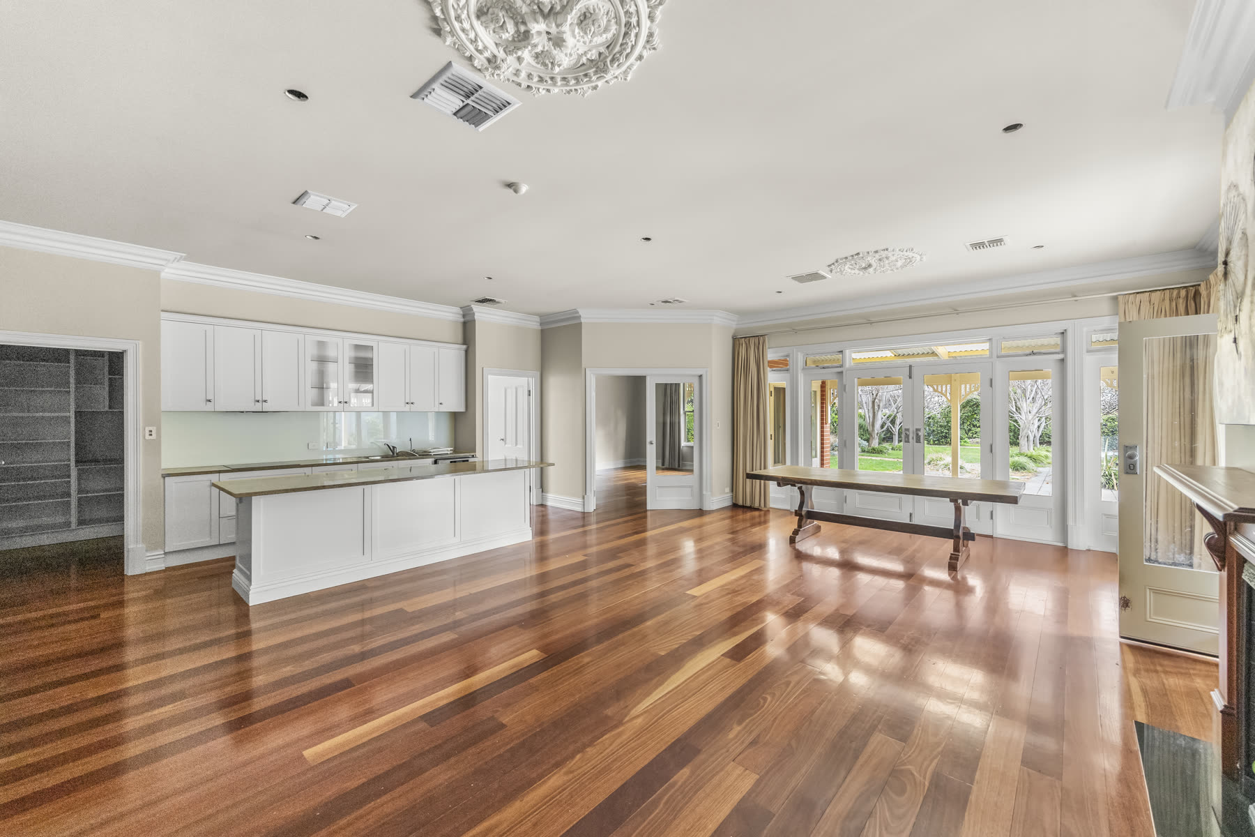 Renovated open-plan kitchen and living area with polished timber floors and a stone island