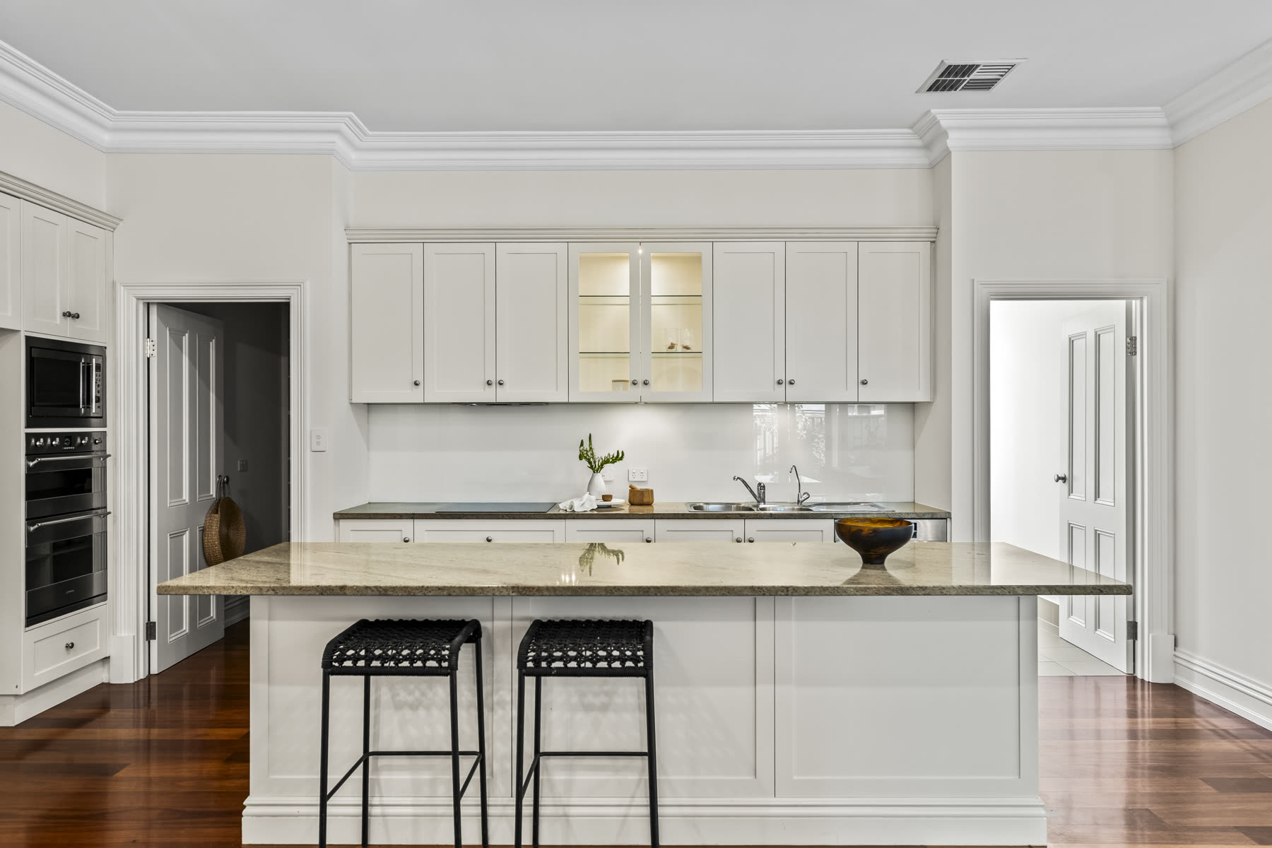Renovated kitchen with white shaker cabinetry and a granite island