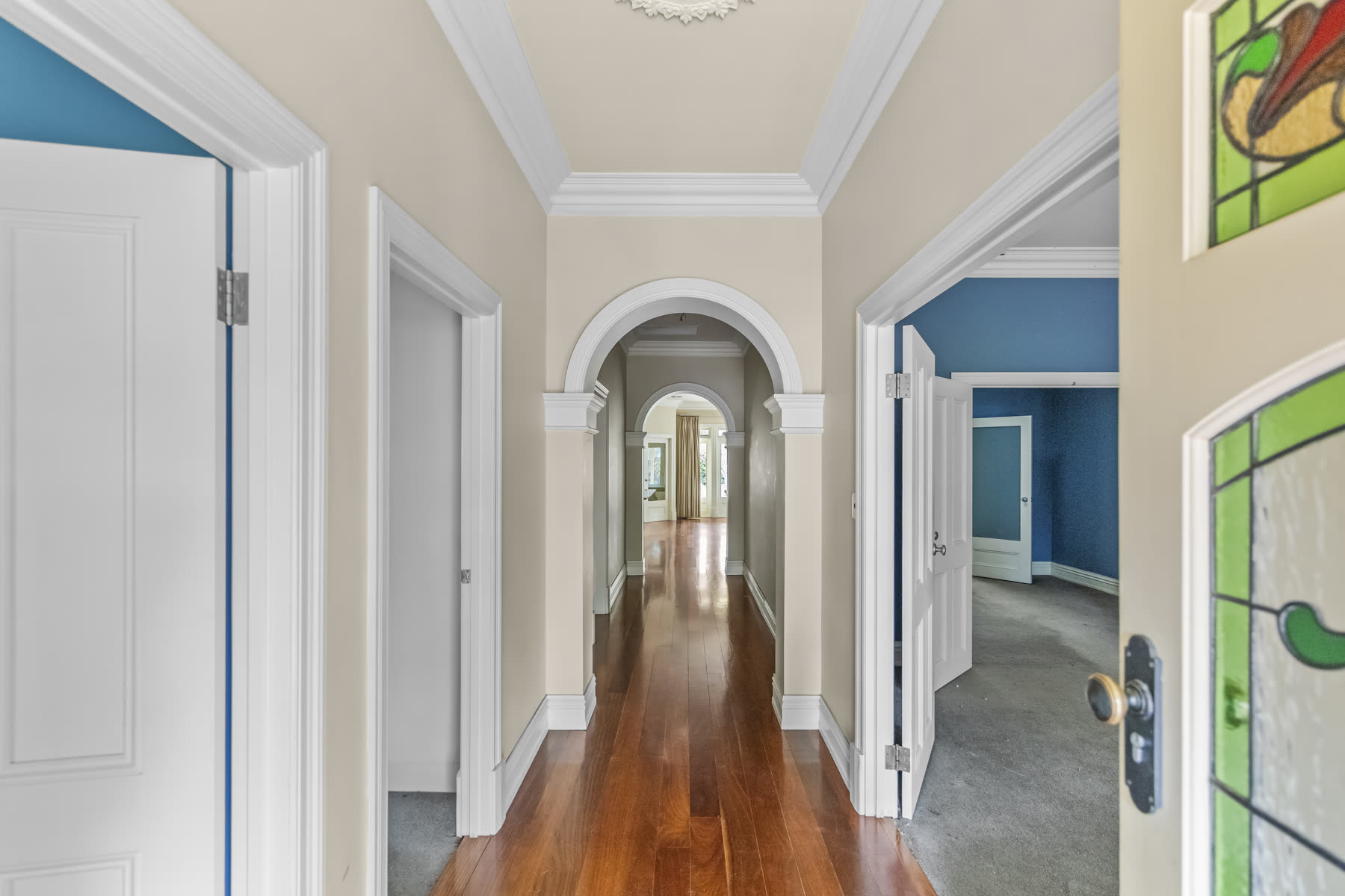 Bright hallway with arched doorways and polished timber flooring